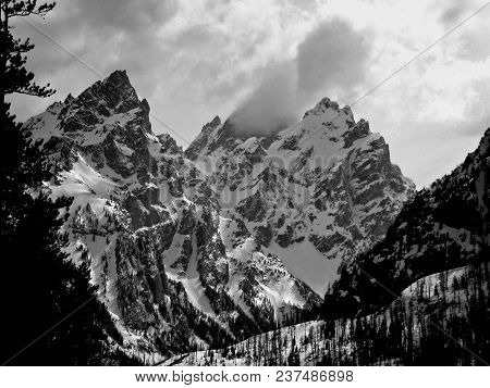 Storm Over The Teton Range: Dark Contrasts Against White Snow And Cloudy Sky. Suitable For Office, R
