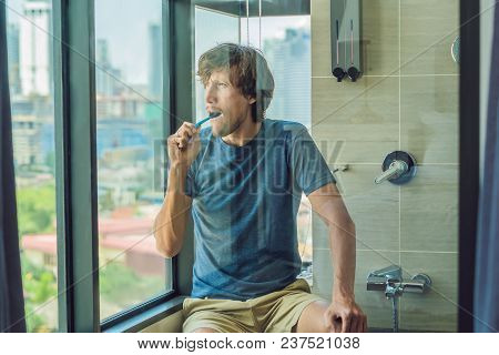 Young Man Brushing His Teeth In His Bathroom.