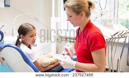 Pediatric Dentist Showing Artificial Jaw To Her Patient