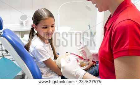 Dentist Showing How To Use Toothbrush To Her Little Patient