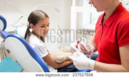 Closeup Of Pediatric Dentist Teaching Girl About Tooth Hygiene