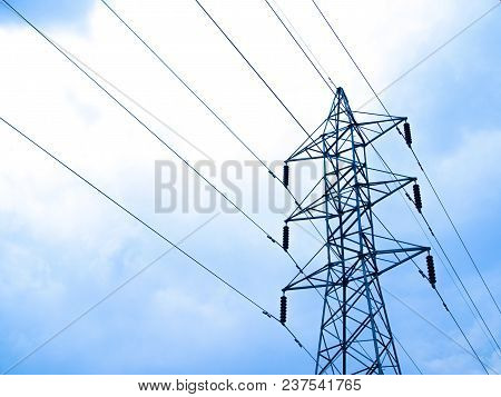 High Voltage Lines And Power Pylons With Clound In The Blue Sky
