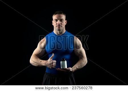 Sportsman With Vitamin Bottle Show Thumbs Up. Food And Diet For Sport And Fitness. Nutrition Supplem