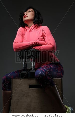 Attractive Fitness Woman In Sportswear Posing With Dumbells In Sudio On Grey Background