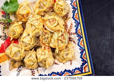 Traditional Kazakh manti steamed with mincemeat as top view on a plate 