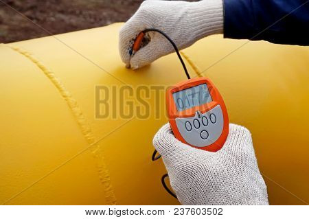 The Gas Pipeline. Measurement Of The Thickness Of The Paint Instrument. The Worker Controls The Thic