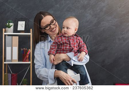 Happy Beautiful Business Mom Working In Office While Spending Time With Her Cute Baby. Business, Mot