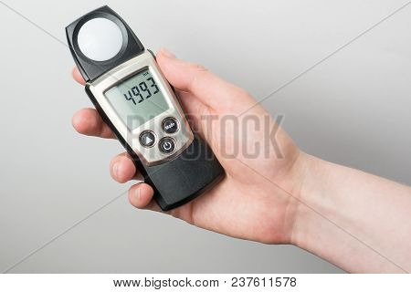 Man Holds In His Hand An Instrument For Measuring Illumination