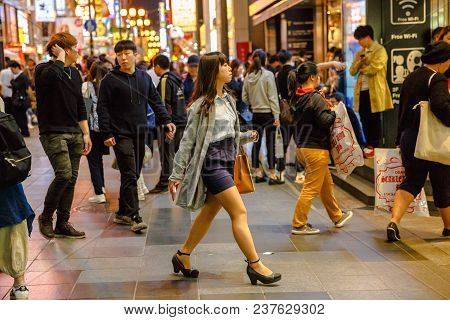 Osaka, Japan - April 29, 2017: Japanese Woman Walking At Night In Dotonbori Area Of Osaka, Namba Dis