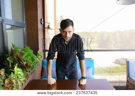 Young Businessman Standing At Office And Wearing Black Shirt. Concept Of Responsibility And Success,