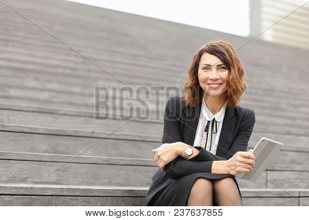 Businessladysitting On Stairs With Tablet. Concept Of Working In Open Ait And Modern Technology, Bus