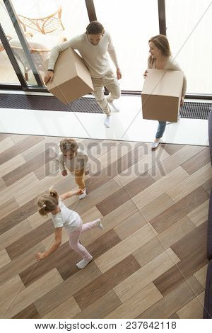 Children Playing Having Fun Exploring Luxury Living Room While Parents Holding Boxes Entering House 