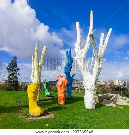 Vila Nova de Famalicao, Portugal - March 31, 2018: Urban art made of colorful painted dead trees in Parque da Devesa Urban Park.