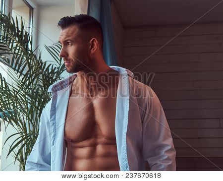 Close-up Portrait Of A Tall Bearded Male With A Muscular Body, Dressed In A White Shirt And Jeans, L