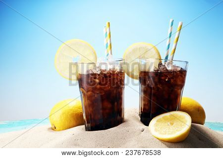 Softdrink With Ice Cubes, Lemon And Straw In Glass.