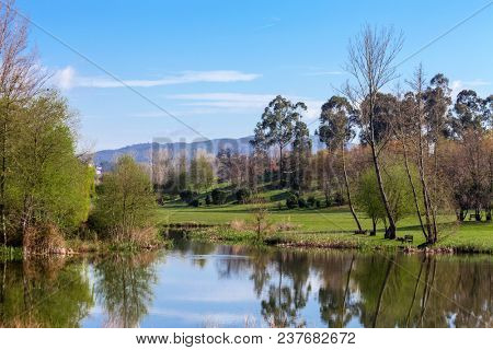 Lake or pond formed by the Pelhe river in Parque da Devesa Urban Park in Vila Nova de Famalicao, Portugal. Built near the city center 