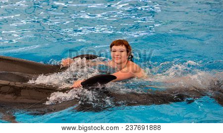 Young Happy Girl Swimming With Dolphin