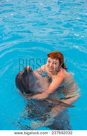 Young Happy Girl Hugs With Dolphin