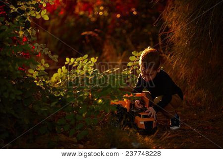 Little Boy Play With A Car Outdoor.
