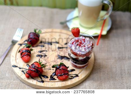 Sweet English Trifle Dessert With Blueberry Cream , Strawberries And Gkass Of Coffee Latte Back On A