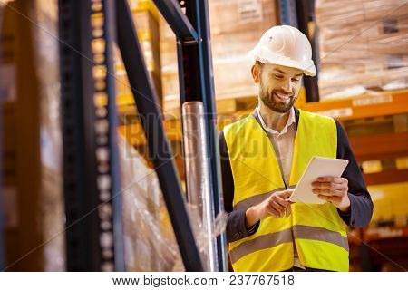 Inventory Control. Positive Smart Man Looking At His Tablet While Doing The Inventory Control
