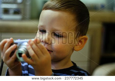 A Small Boy Holds A Camera In His Hands And Smiles, Looks At The Screen. Memories, Photography, Vide