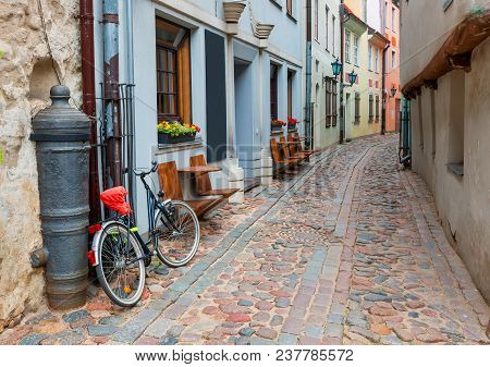 Narrow Medieval Street In Old Riga City, Latvia. In Old Riga City Tourists Can Find A Unique Atmosph