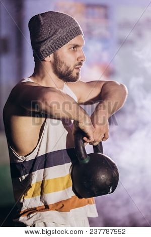 Handsome Man Doing Exercise With Dumbbells. Photo Of Muscular Man Isolated On Dark Background. Stren