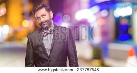 Middle age man, with beard and bow tie with sleepy expression, being overworked and tired at night club
