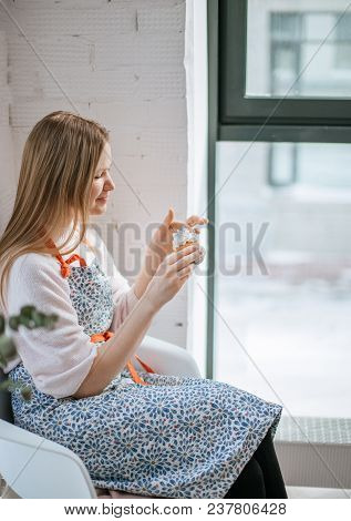 Morning Of Beautiful Young Woman Eating Cupcake While Sitting Near Window At Home