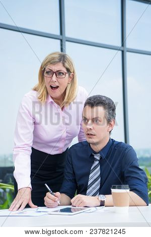 Two Business Colleagues At Outdoor Cafe Seeing Something Shocked. Worried Middle Aged Man And Woman 