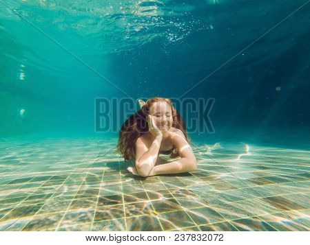 Woman At The Bottom Of The Pool, She Dives Under The Water.