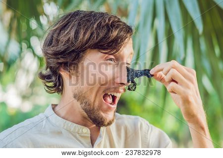 Happy Man With Black Mask On The Face. Photo Man Receiving Spa Treatments. Beauty Skin Care Concept.
