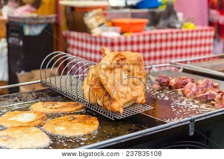 Traditional Hungarian Street Food Langos At Fair. Langos Frying In Boiling Oil