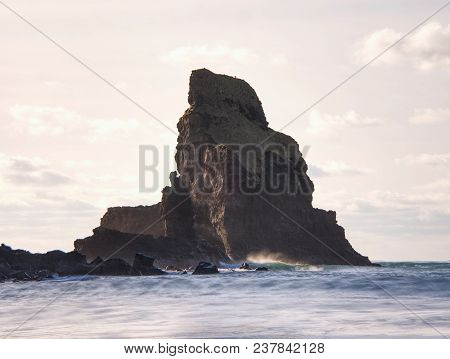 Sharp Silhouette Of A Cliff Against The Background Of Sunset. Sea Waves Break On The Rocks. Talisker