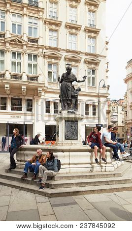 Vienna, Austria - 15 April 2018: People Sit On The Steps Near The Fountain Monument