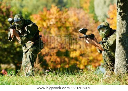 Prootective iki paintball spor oyuncu koyar ve hedefleyen ve shoting dışarıda silahla maske