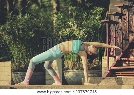 Portrait Of  Woman Playing Yoga At Home Garden