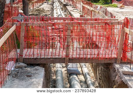 Improvised Wooden Bridge Over The Trench With New District Heating Pipeline System Installations On 
