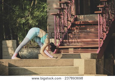 Portrait Of Woman Playing Yoga At Home Garden