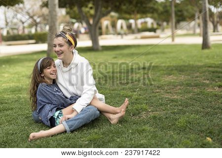 Two Sisters Who Sitting Loving Each Other.