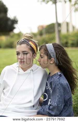 Two Sisters Sitting With Very Serious Faces.