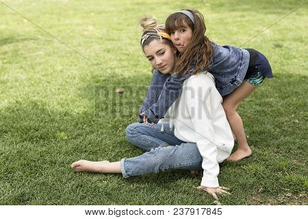 Girl Hugging Behind Her Sister.