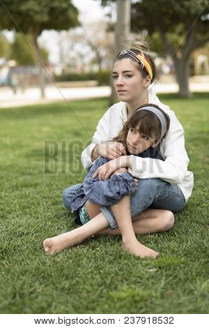 Two Sisters Sitting With Very Serious Faces.