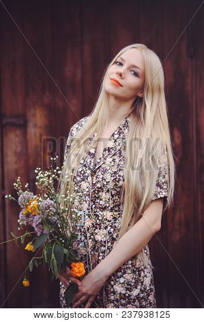 Beautiful Young Woman In Doted Summer Dress On Red Old Wooden Background, Looking At Camera. Rustic