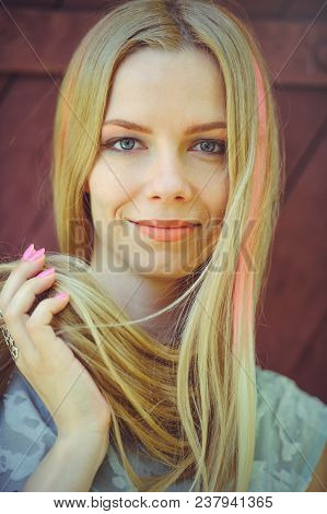 Attractive Modest Young Blond Woman Playing With Hair On Red Wooden Background Her Hair Painted In P