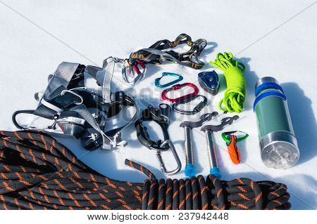 Close-up Of Winter Climbing Equipment On Fresh Snow On A Sunny Day. Carbines With A Rope Gazebo And 