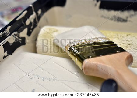 A Close Up Image Of A Used Paint Roller And Paint Brush.