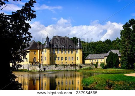 Castle Dyck, In Germany, Reflecting In A Pond.