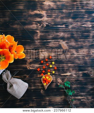 Tulips With Sweets In A Waffle Horn On A Wooden Background.